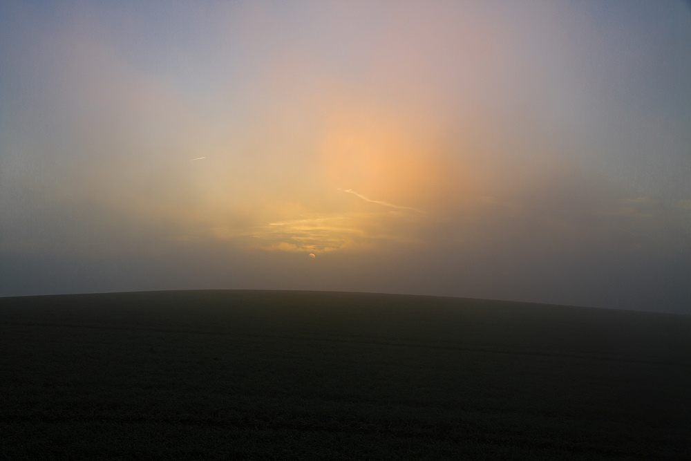 Die Sonne kämpft sich durch den Hochnebel am Morgen