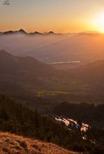 Sonnenstrahlen spalten die Gipfel und erhellen das  Tal