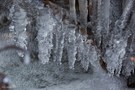 Eiszapfen über dem sprudelnden Bach