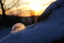 Gefrorene Seifenblase während dem Sonnenaufgang in der Rhön